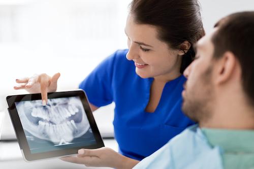 Dentist showing digital xrays to patient