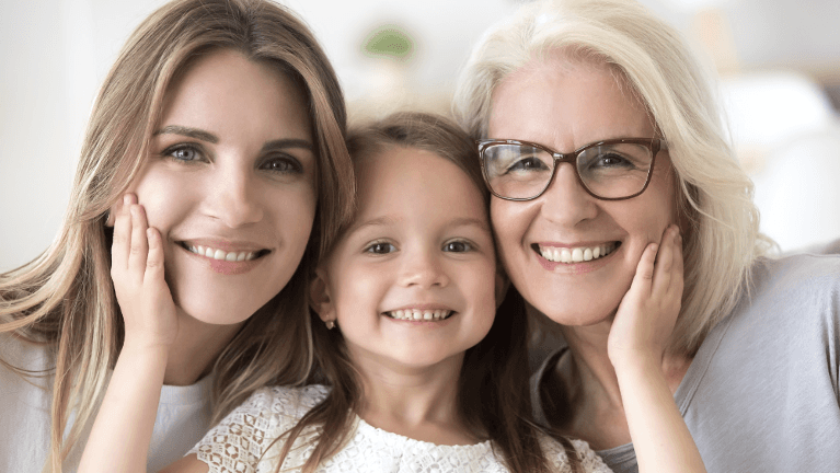 mother, young daughter, and grandma smiling 